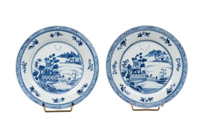 une paire d'assiettes bleues et blanches ornées d'un paysage