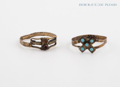 two rings with turquoise stones on them sitting on a white surface