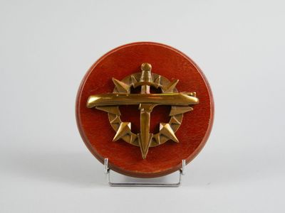 une image représentant une broche rouge et dorée ornée d'une croix