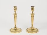 a pair of brass candlesticks on a white background