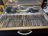 a drawer full of knives and knives on a table