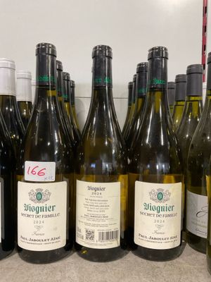 Des bouteilles de vin sont alignées sur le comptoir d'un caviste.