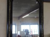 a mirror on a table with a vase of flowers on it