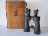 deux jumelles posées à côté d'un sac sur une table