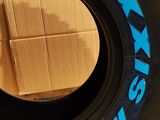 a tire that has been painted blue and has a cardboard box in it