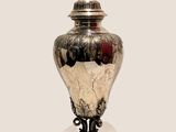 a silver vase with a lid sitting on a table