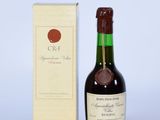 une vieille bouteille de vin posée à côté d'un carton de vin