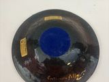 un bol bleu et noir sur une surface blanche
