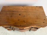 a small wooden table with a drawer on top of it