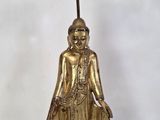 une statue en or représentant une femme tenant une bougie
