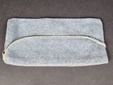 a small grey bag with a zipper on top of it