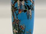 a blue vase with a painting of flowers on it