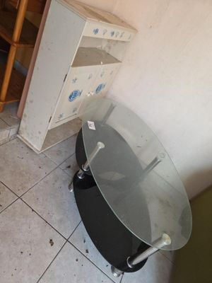 une table avec un plateau en verre, dans un coin de la pièce