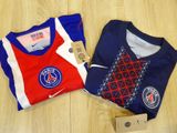 Deux t-shirts sont posés l'un à côté de l'autre sur un plancher en bois.