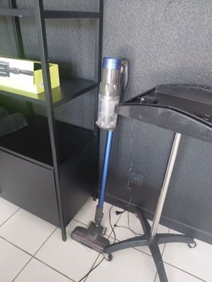 a vacuum that is on the floor next to a shelf