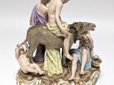 a figurine of a man and a woman sitting on top of a cow