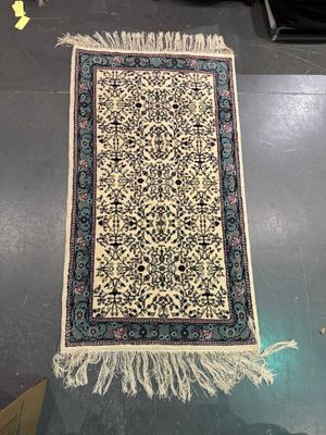 an oriental rug on a table in a room with other items