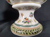 a white vase with a floral design on it