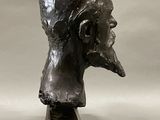 sculpture of a man ' s head on a pedestal on a white background