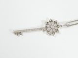 a close up of a key on a chain with a flower on it