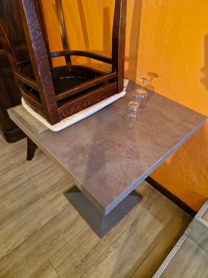 une petite table sur laquelle se trouvent une chaise et un miroir