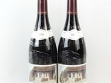 deux bouteilles de vin rouge posées l'une à côté de l'autre sur une surface blanche