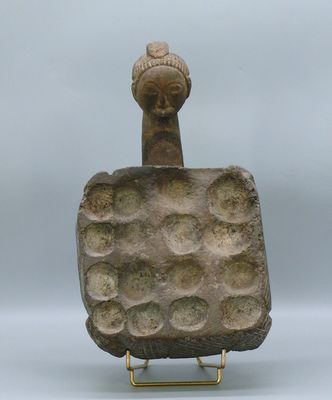 une ancienne statue en pierre représentant une femme coiffée d'un chapeau