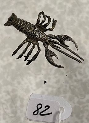 une photo d'un objet métallique sur le dos duquel se trouve un homard