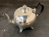 a silver tea pot sitting on top of a table