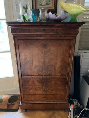 une armoire en bois surmontée de vases en verre
