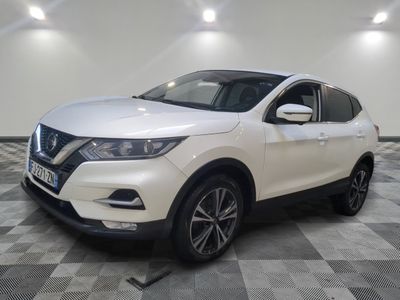 une Nissan QX-V blanche garée sur un sol à damier