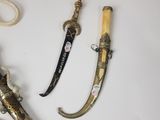 three different types of knives on a white surface
