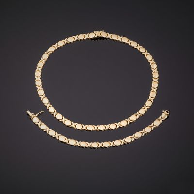 un ensemble composé d'un collier et d'un bracelet en or sur fond noir