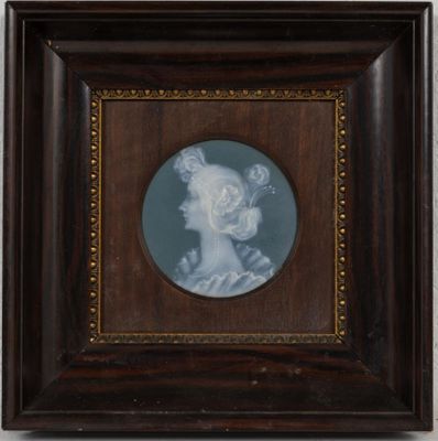 portrait of a woman in profile in a dark wood frame