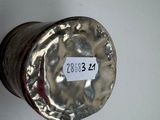 a silver vase with a label on it on the wall