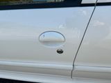 un gros plan sur la poignée d'une portière de voiture sur laquelle est collé un autocollant