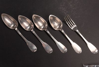 cinq cuillères et une fourchette sur une table noire