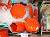 many orange pots and pans on display in a store