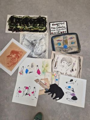 une personne debout sur le sol, à côté d'une pile de dessins