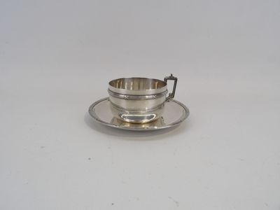 tasse à thé et soucoupe plaquées argent, posées sur une soucoupe