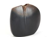 a black vase that is sitting on a white surface