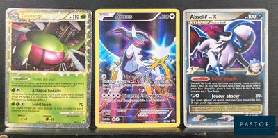 trois types différents de cartes Pokémon posées sur une table