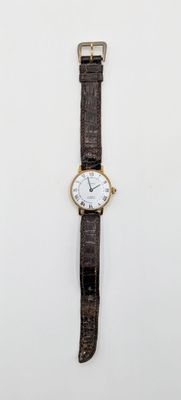 an image of a watch on a white surface with a black strap
