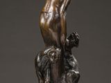 a bronze statue of a man sitting on top of a table