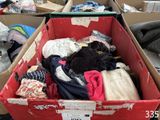 une boîte remplie de vêtements posée par terre