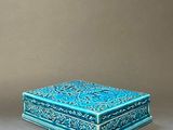 pair of blue and green boxes with designs on them on a gray surface
