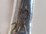 a close up of a silver spoon with a flower design on it