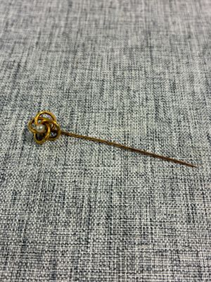 un gros plan d'une broche en or ornée d'une fleur