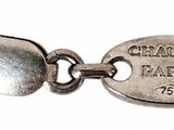 a close up of a silver bracelet with a tag on it