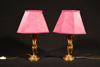 une paire de lampes roses posées sur une surface noire, sur fond noir